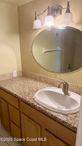 a bathroom with a granite countertop sink and mirror
