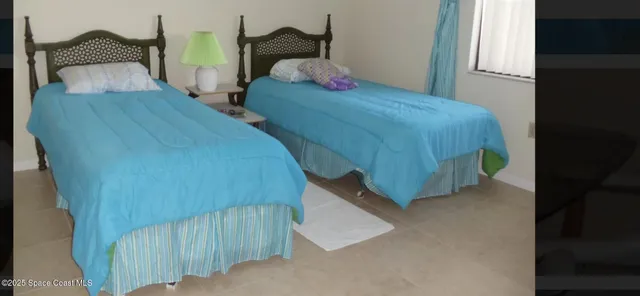 a bedroom with two bed and a window