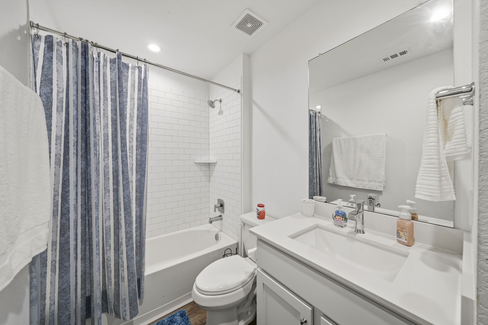 919 Tall Shire Court Rosharon, TX 77583 - Photo 15 of 19 A clean, functional guest bath offering a shower-tub setup framed by classic tile work. The efficient layout incorporates a spacious single sink counter, broad mirror, and dedicated storage.