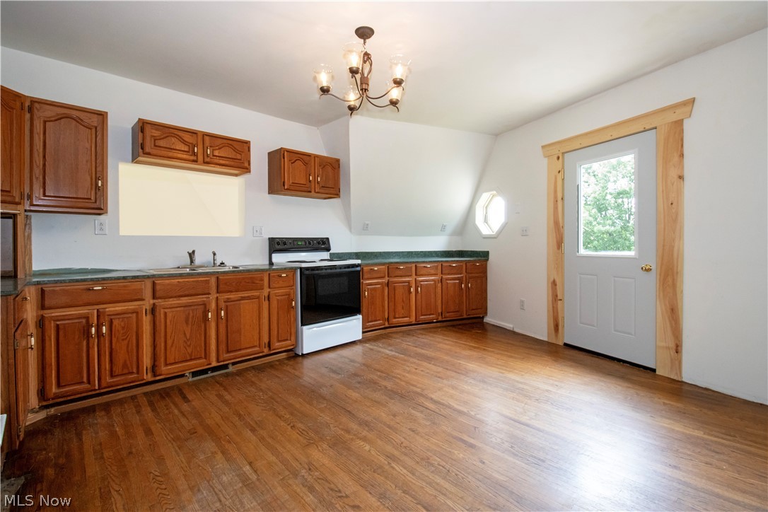 5660 Force Road Shreve, OH 44676 - Photo 29 of 38 Kitchen with white electric range, wood-type flooring, and a chandelier