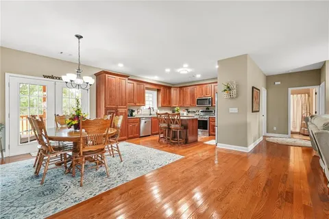 a kitchen with stainless steel appliances granite countertop a stove a sink dishwasher a microwave oven with a dining table and chairs