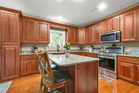 a kitchen with stainless steel appliances granite countertop wooden cabinets a stove top oven a sink and dishwasher
