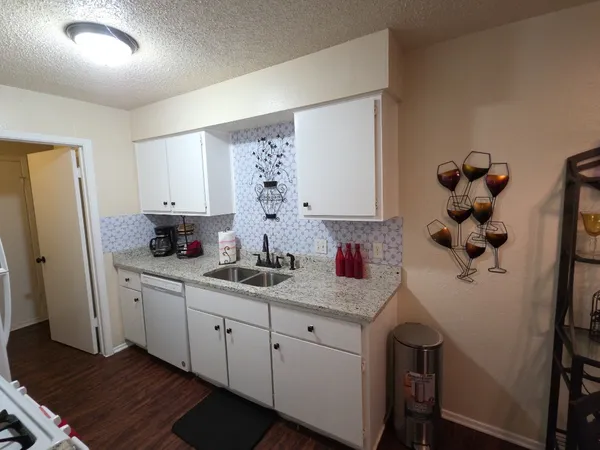 a kitchen with white cabinets and sink