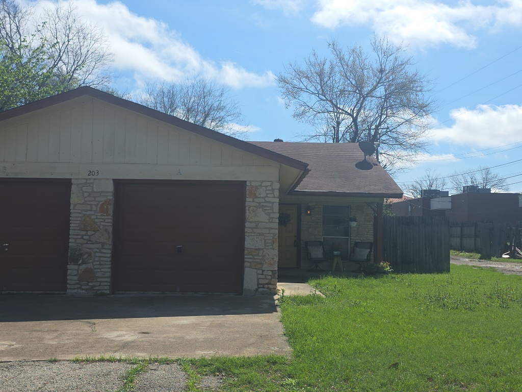 203 2nd Street North, Unit A Pflugerville, TX 78660 - Photo 25 of 25 Single story home with an attached garage, stone siding, driveway, and board and batten siding