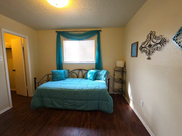 a bedroom with a bed and wooden floor