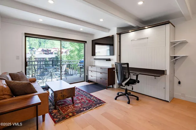 a view of a livingroom with workspace and a window
