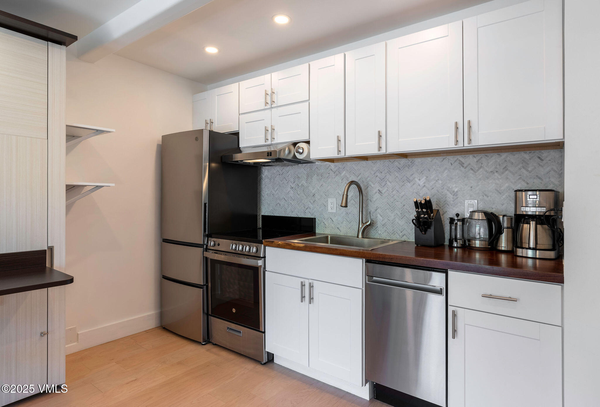 508 East Lionshead Circle, Unit 214 Vail, CO 81657 - Photo 5 of 9 a kitchen with stainless steel appliances granite countertop white cabinets sink and refrigerator