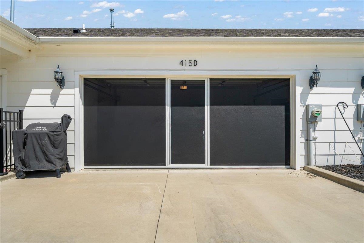 415 Abbey Road, Unit D Munford, TN 38058 - Photo 25 of 35 Attached garage with white siding, equipped with a three-panel sliding screen door system