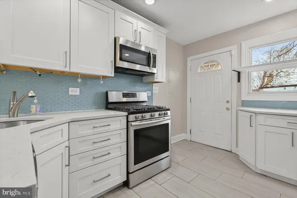 a kitchen with cabinets stainless steel appliances and sink