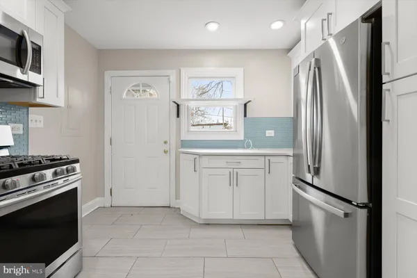 a kitchen with stainless steel appliances granite countertop a refrigerator and a stove top oven