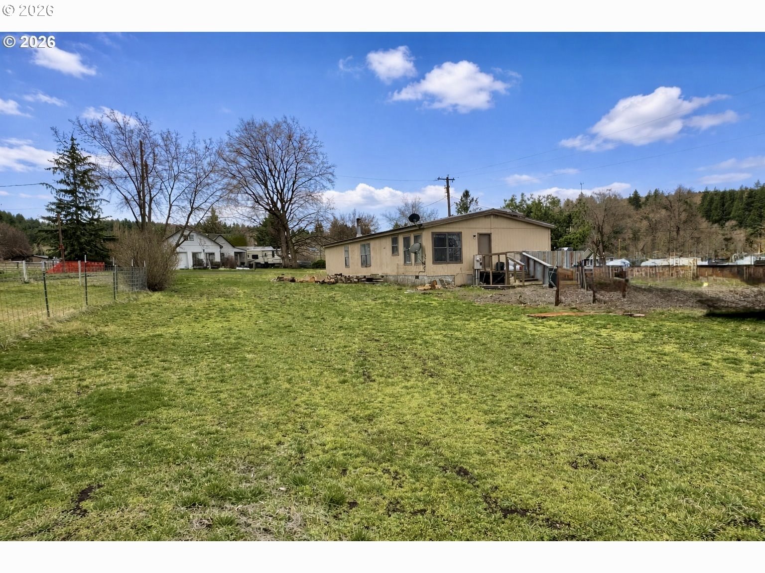 701 2nd Street Cove, OR 97824 - Photo 12 of 13 a view of a house with a yard fire pit and trees in the background