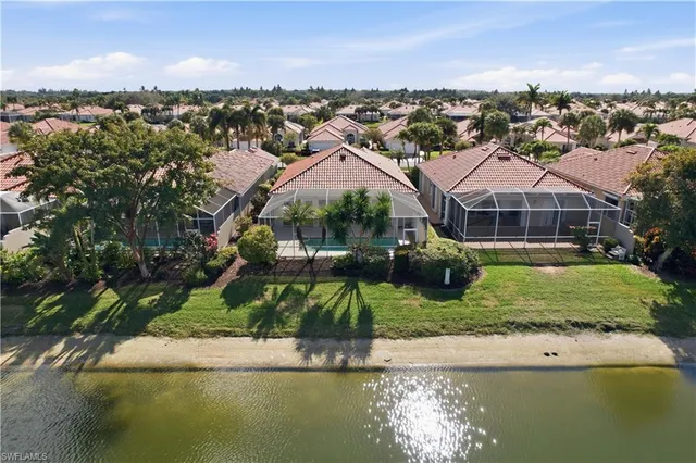 an aerial view of residential houses with outdoor space and lake view