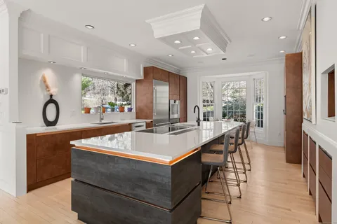 a living room with furniture a large window and wooden floor