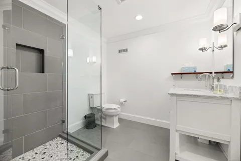 a bathroom with a toilet a sink and mirror