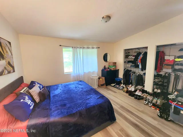 a bedroom with a bed and wooden floor