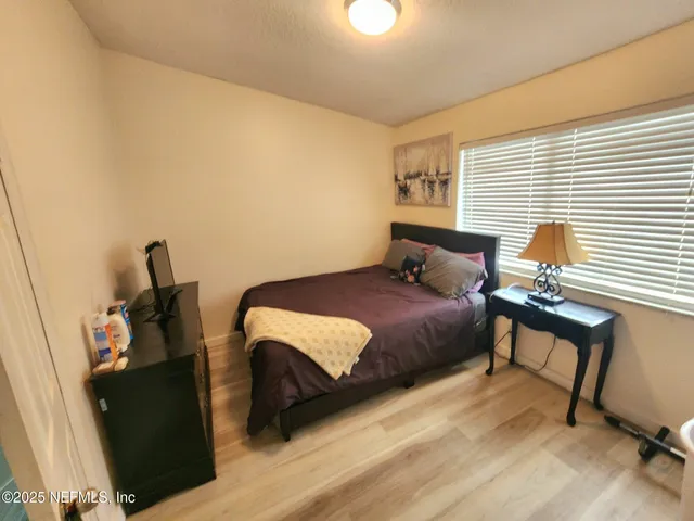 a bedroom with a bed and wooden floor