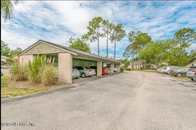 a view of a house with a yard and potted plants