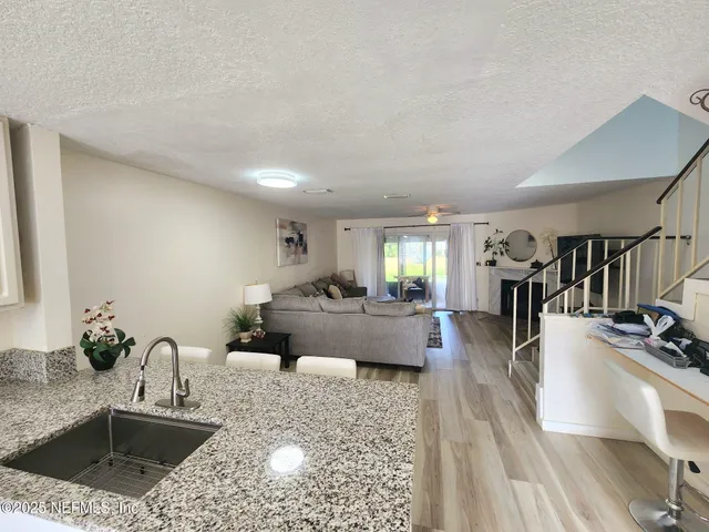 a kitchen with stainless steel appliances granite countertop a sink a stove and a wooden floors