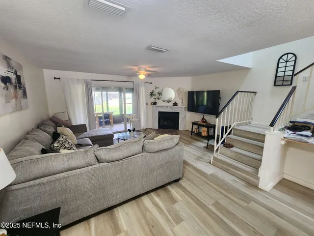 a living room with furniture or wooden floor and a flat screen tv