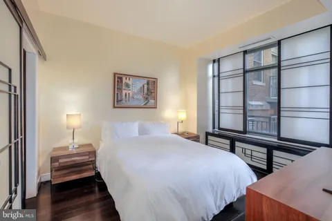 a bedroom with a bed and a flat tv screen on a dresser