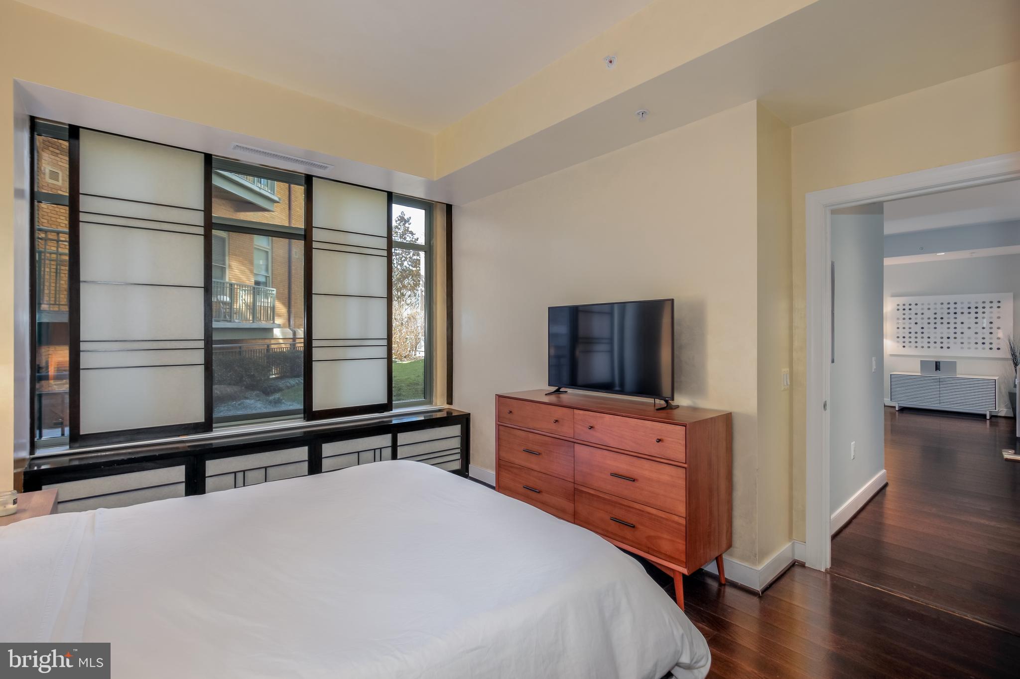 2425 L Street Northwest, Unit 211 Washington, DC 20037 - Photo 18 of 43 a bedroom with a bed and a flat tv screen on a dresser