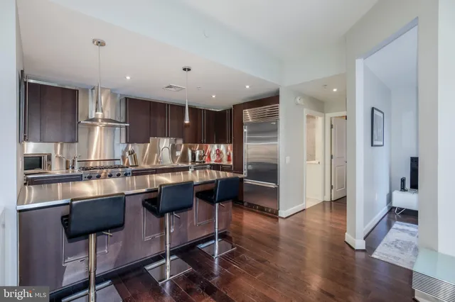 a kitchen with stainless steel appliances granite countertop a refrigerator and a stove top oven