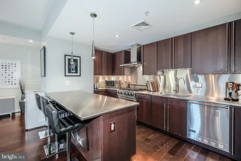 a kitchen with kitchen island granite countertop a sink counter and chairs