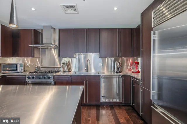 a kitchen with stainless steel appliances granite countertop a refrigerator and a stove top oven