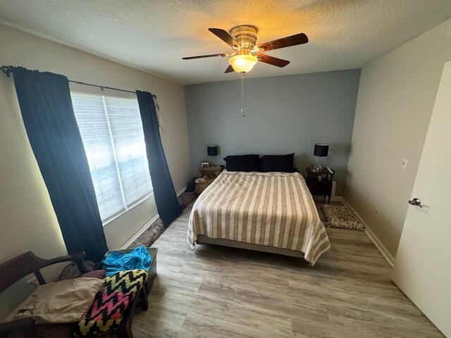 1465 Malibu Circle Northeast, Unit 101 Palm Bay, FL 32905 - Photo 15 of 25 a bedroom with a bed and a chandelier