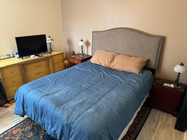 1465 Malibu Circle Northeast, Unit 101 Palm Bay, FL 32905 - Photo 20 of 25 a bedroom with a bed and a flat tv screen on dresser