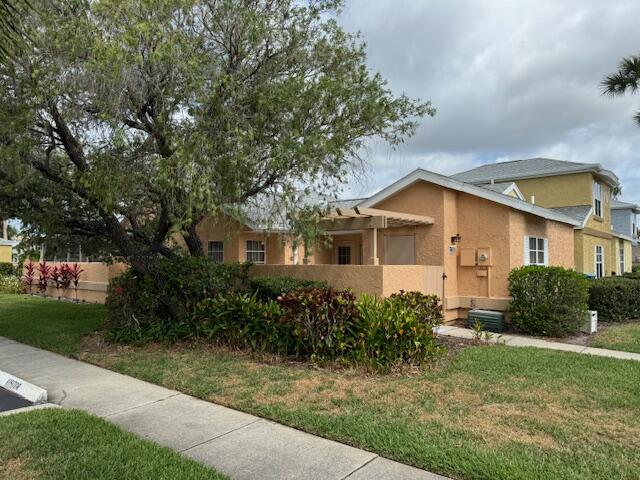 1465 Malibu Circle Northeast, Unit 101 Palm Bay, FL 32905 - Photo 2 of 25 a view of a yard in front of a house with plants and large trees