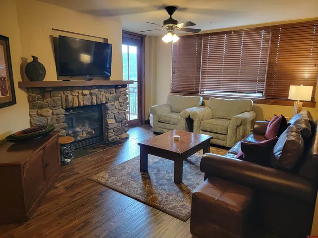 a living room with furniture a flat screen tv and a fireplace