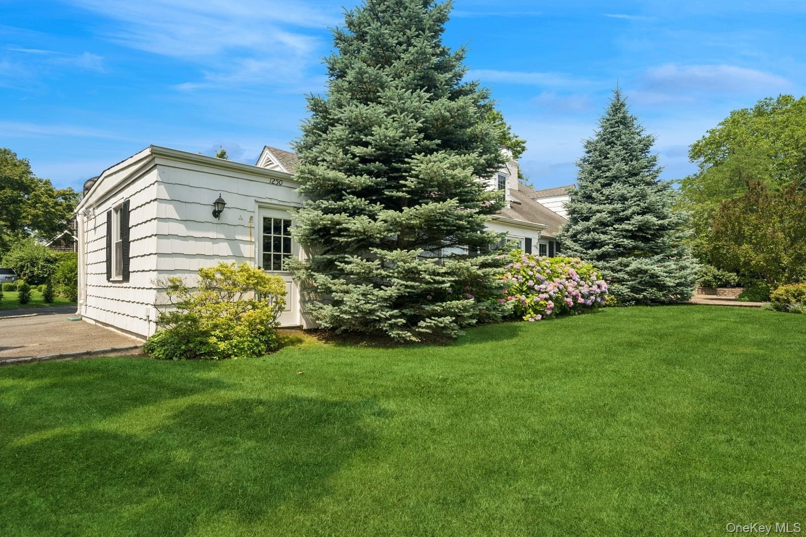 1250 Harbor Road Hewlett, NY 11557 - Photo 15 of 18 a front view of a house with a garden