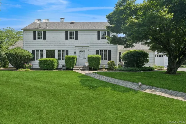 a front view of a house with a yard and trees