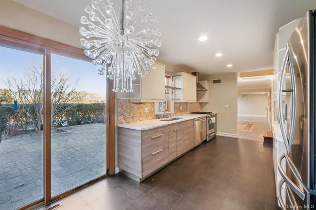 a kitchen with stainless steel appliances granite countertop a refrigerator a sink and a stove