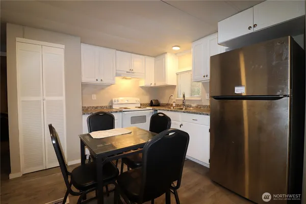 a kitchen with a table chairs refrigerator and a sink