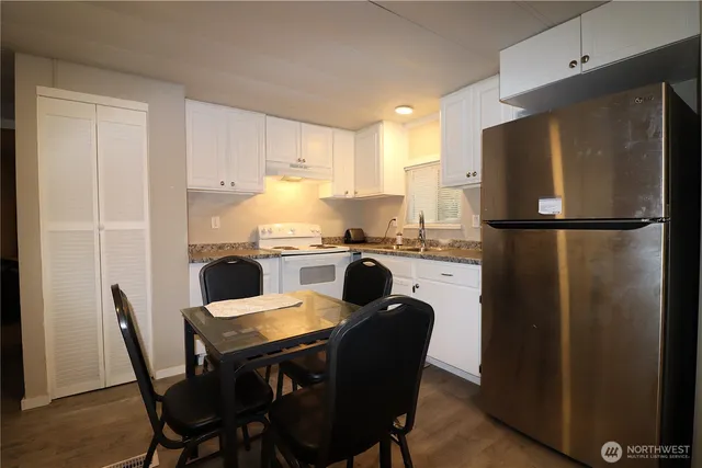 a kitchen with a table chairs refrigerator and a sink