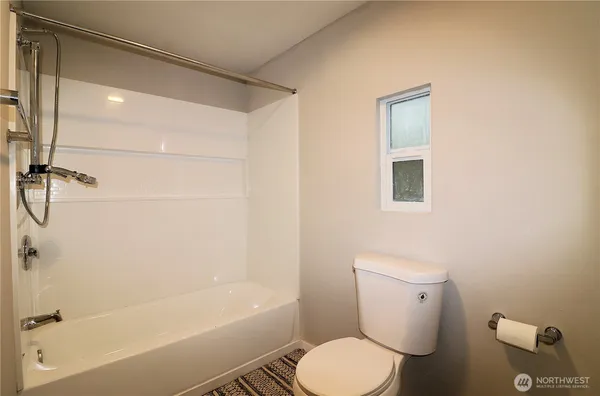 a white toilet sitting next to a bath tub and shower