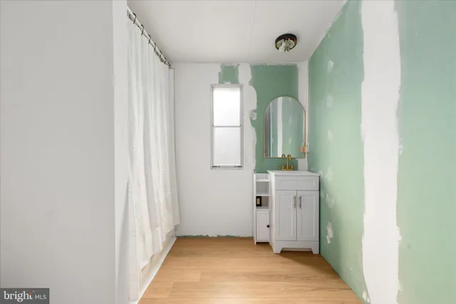 a view of a hallway with wooden floor and cabinet