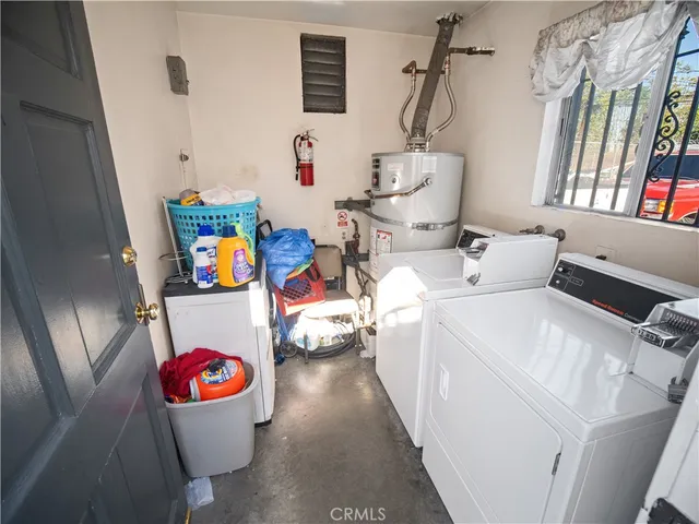 a utility room with dryer washer and a view of living room