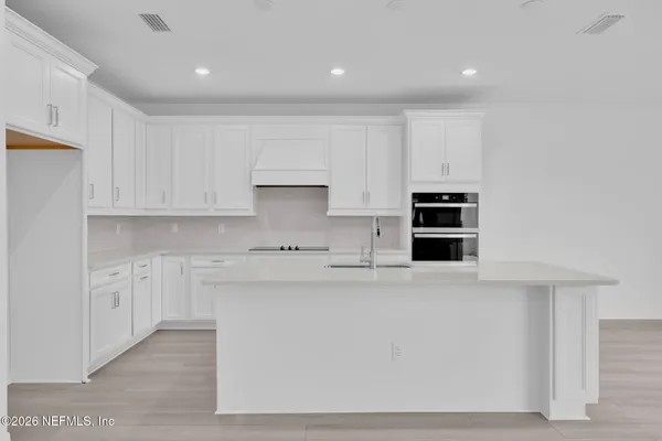 a kitchen with stainless steel appliances granite countertop a sink and a wooden floors
