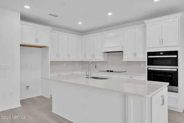 a view of kitchen with stainless steel appliances granite countertop a stove and a sink