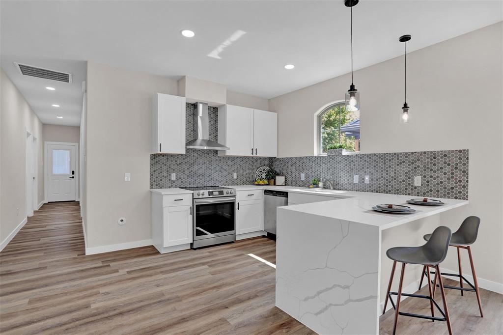 a kitchen with a stove a sink a dining table and chairs
