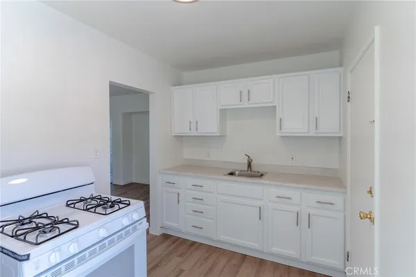 a kitchen with granite countertop a sink stove and cabinets