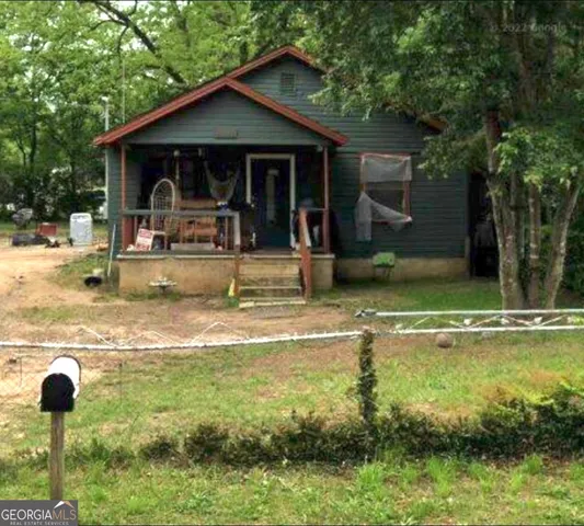 a view of a house with swimming pool next to a yard