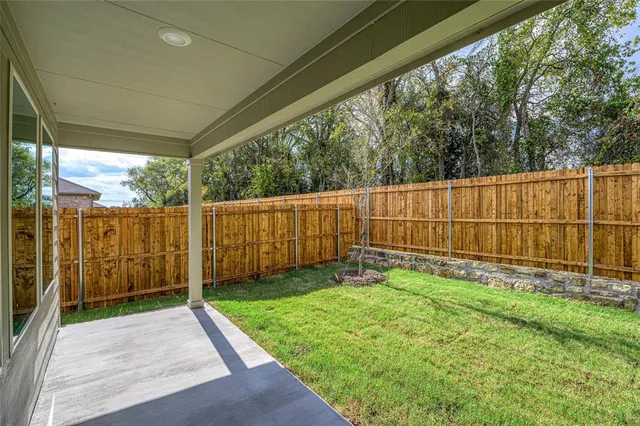 a view of a backyard with wooden fence