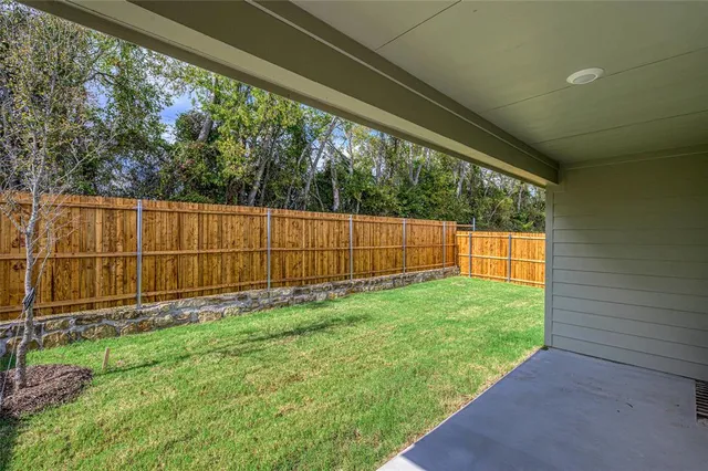 a view of a backyard with wooden fence