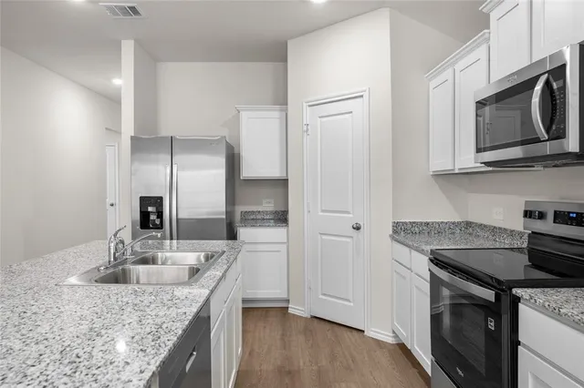 a view of kitchen with stove and cabinets