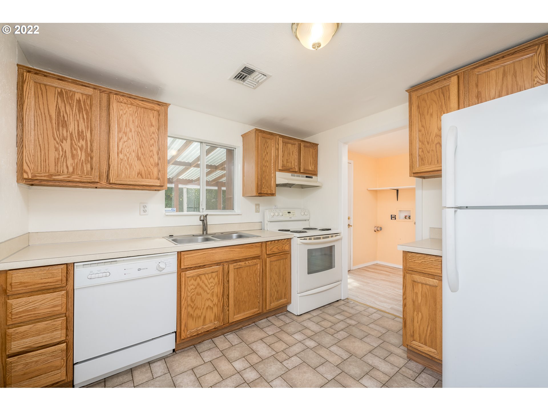809 60th Street Springfield, OR 97478 - Photo 6 of 17 a kitchen with stainless steel appliances granite countertop a refrigerator sink stove and white cabinets