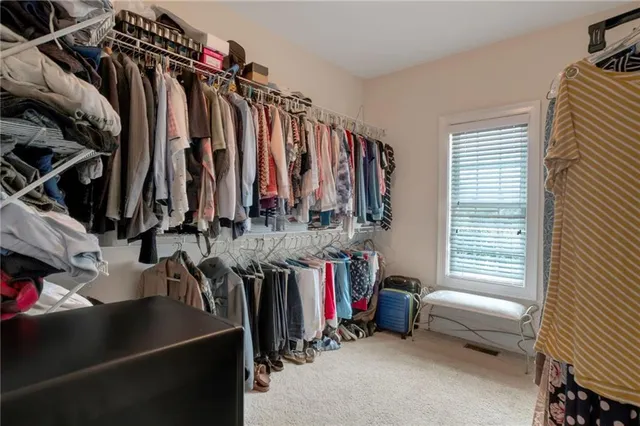 a view of walk in closet with clothes and shoes